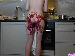 Zrela mama s tetovažo hobotnice na zadnjici kuha večerjo in vas ignorira