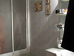 אישה במקלחת מציגה את החזה הגדול והקימורים שלה בסרטון אמצעי
