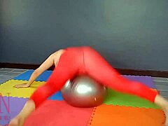 Regina Noir, een volwassen vrouw, beoefent yoga in de sportschool terwijl ze een rood turnpakje, yoga panty's en geschoren lingerie draagt