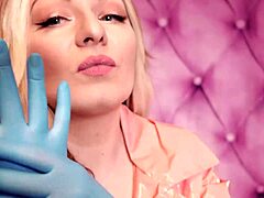 Aria Grander, seorang MILF yang menggoda, mengenakan pakaian fetishistik termasuk mantel PVC pink dan sarung tangan nitril biru, menampilkan lekuk tubuhnya yang menakjubkan dalam video buatan sendiri ini