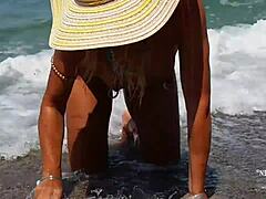 Reife Frau mit gedehnten Nippelpiercings und mehreren Muschipiercing am Strand