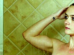 Une magnifique mannequin brune se baigne dans une douche chaude