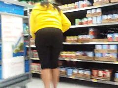 Een zwarte vrouw pronkt met haar grote kont in de winkel