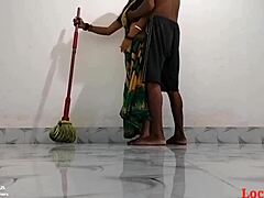 Reife indische mutter in grünem saree macht sich im hotelzimmer schmutzig