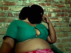 Het verleidelijke lichaam van een stiefmoeder in een saree in een hete video