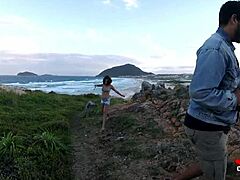Vzbujajoč video mladega dekleta, ki fafa na skalah ob morju