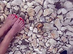 Gezichts- en plasspel op de voeten en kont van een milfs in een openbare strandomgeving